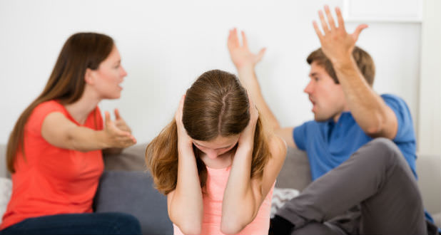 The Effects of Divorce on Children shown with girl covering her ears from parents' argument