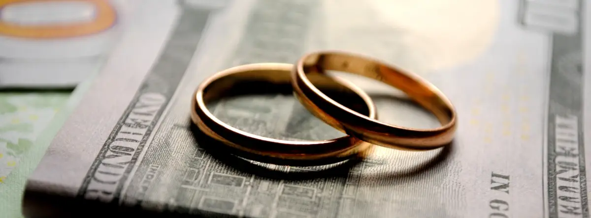 Divorce Finances represented by two staked rings on a $100 bill