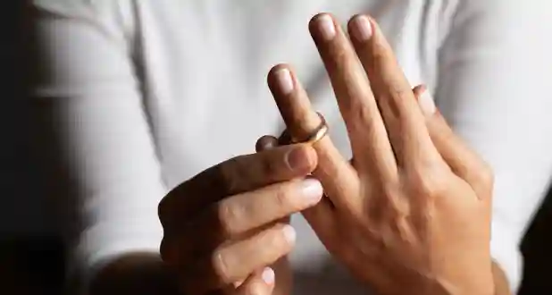 person removing wedding ring in divorce